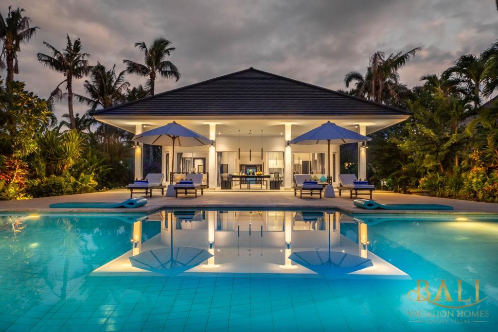 a villa with a swimming pool at night at Villa Akasa Segara Beachfront and Private Pool in Banjar