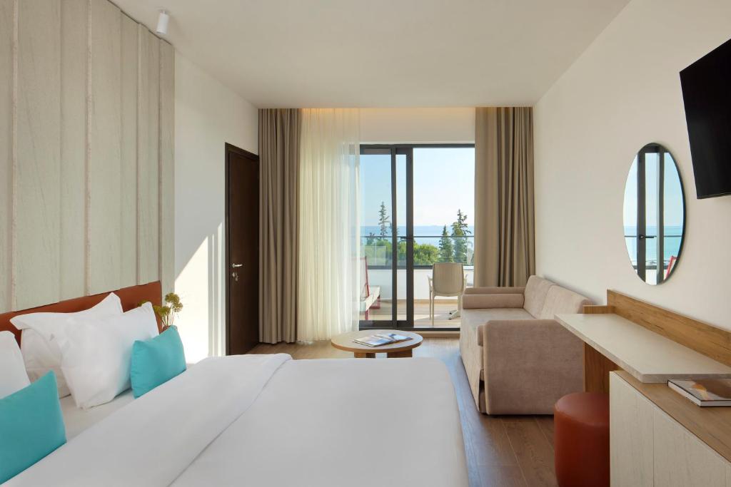 a hotel room with a large bed and a living room at Sol Tropikal Durrës in Durrës