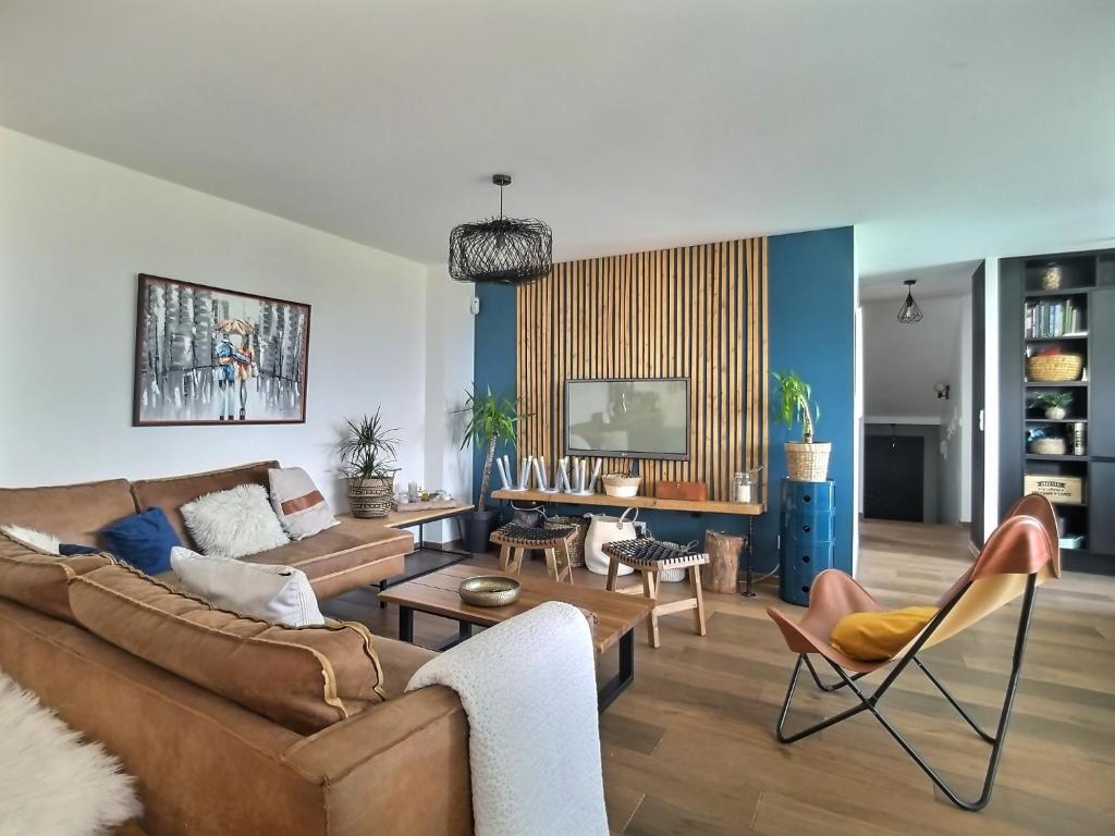 ein Wohnzimmer mit einem Sofa und einem Tisch in der Unterkunft Détente, confort et sérénité, aux portes de Genève in Collonges