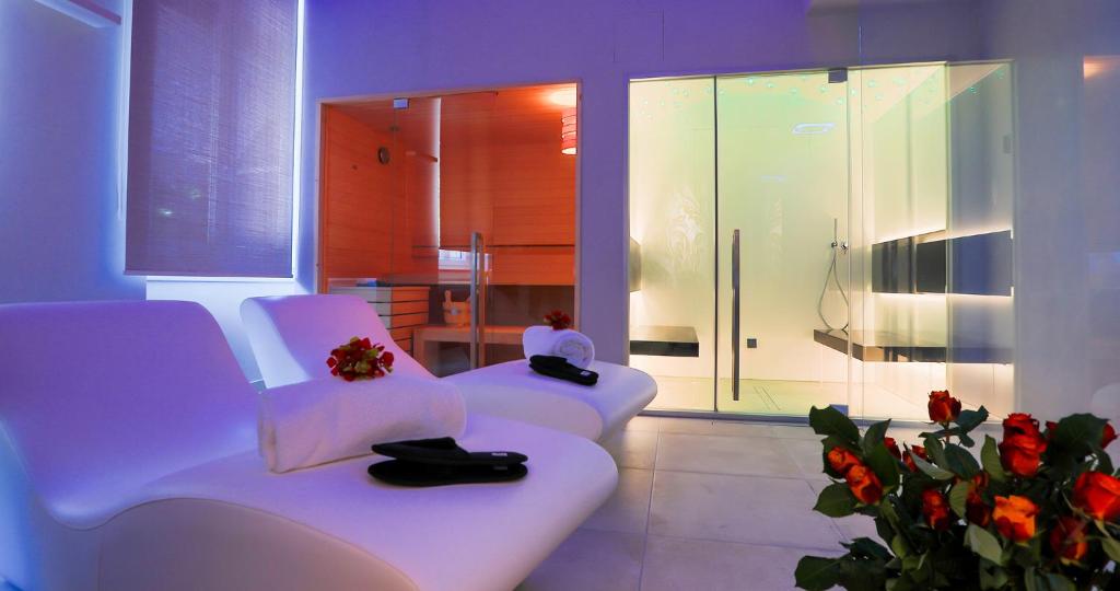 Dos sillas blancas en una habitación con flores en Hotel Tigullio Et De Milan en Santa Margherita Ligure
