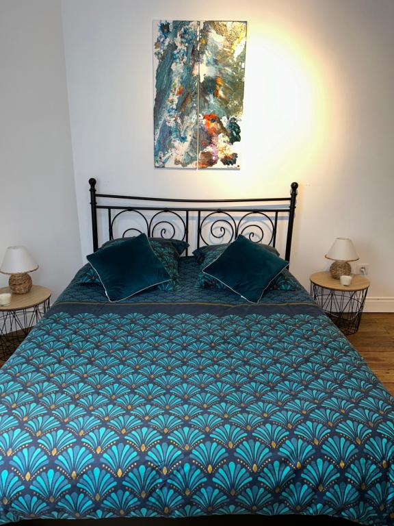 - un lit avec une couette bleue et 2 lampes dans l'établissement chambre zen château de la Bouchatte, à Chazemais
