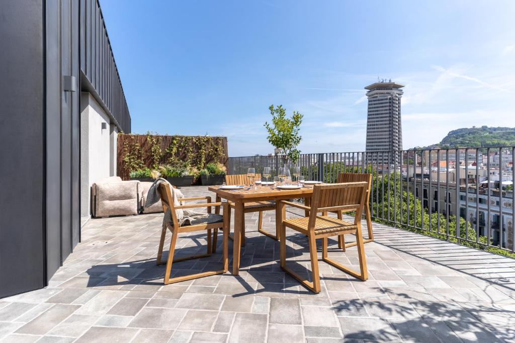 un patio con tavolo e sedie in legno sul balcone. di TSA La Rambla a Barcellona