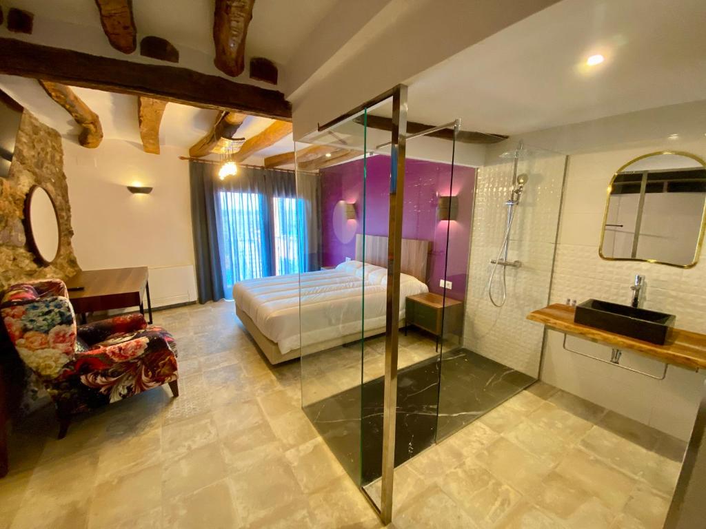 een slaapkamer met een bed en een douche en een badkamer bij Hotel Boutique Malanquilla Inedita in Malanquilla