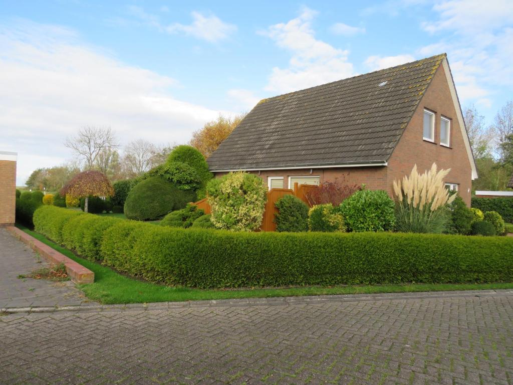 a house with a nicely landscaped yard at Ferienhaus PH 17 in Krummhörn