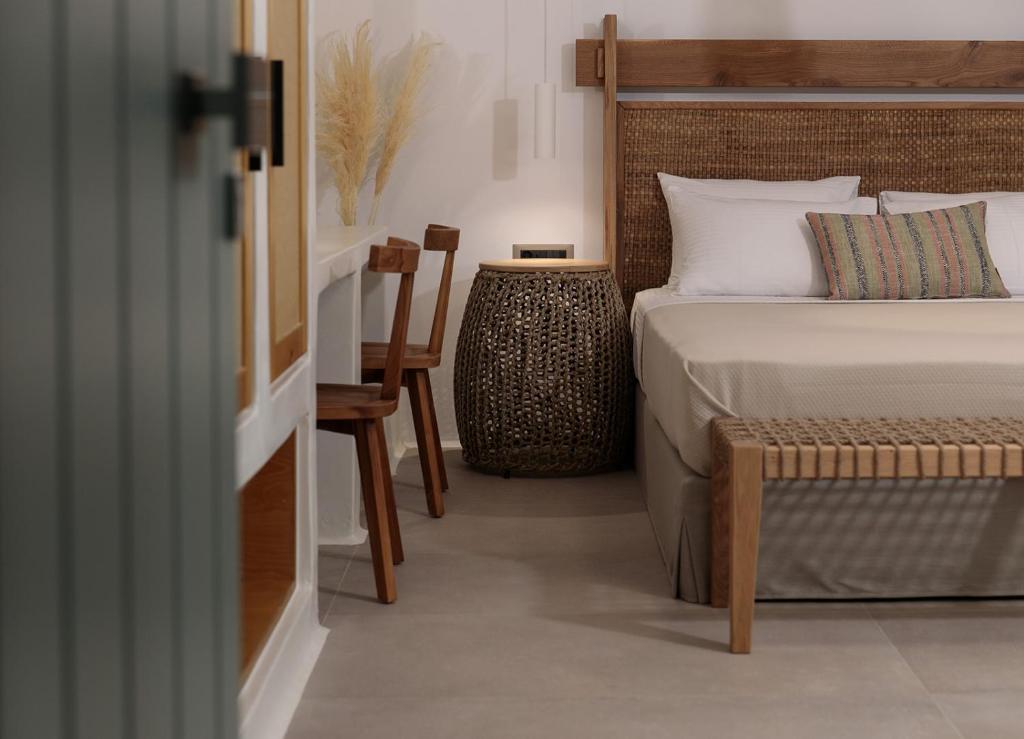 a bedroom with a bed and a table and a chair at Makava Suites Naxos in Naxos Chora