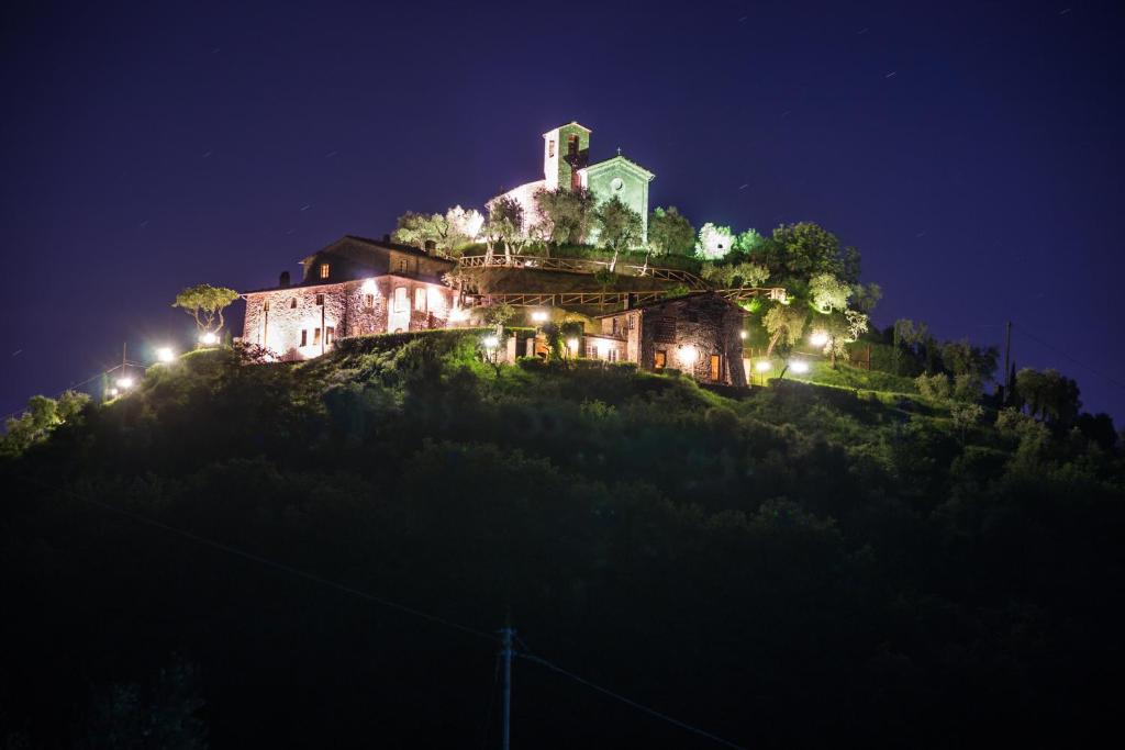 une maison au sommet d'une colline la nuit dans l'établissement Castello Di Mammoli, à Lucques