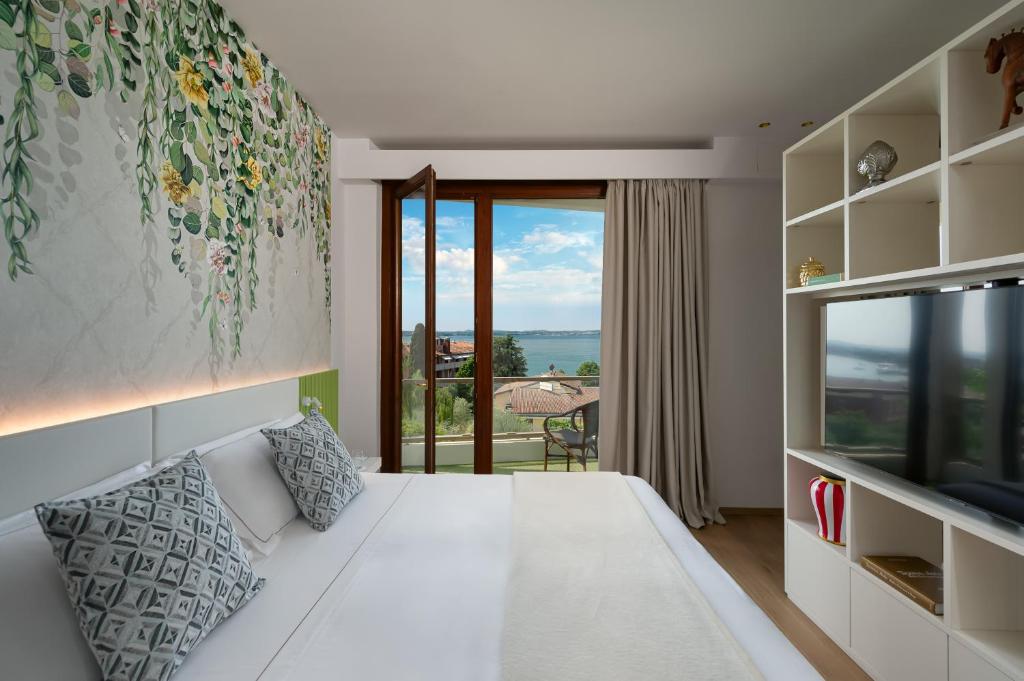 シルミオーネにあるOlivi Hotel & Natural Spaのベッドルーム(白いベッド1台、大きな窓付)