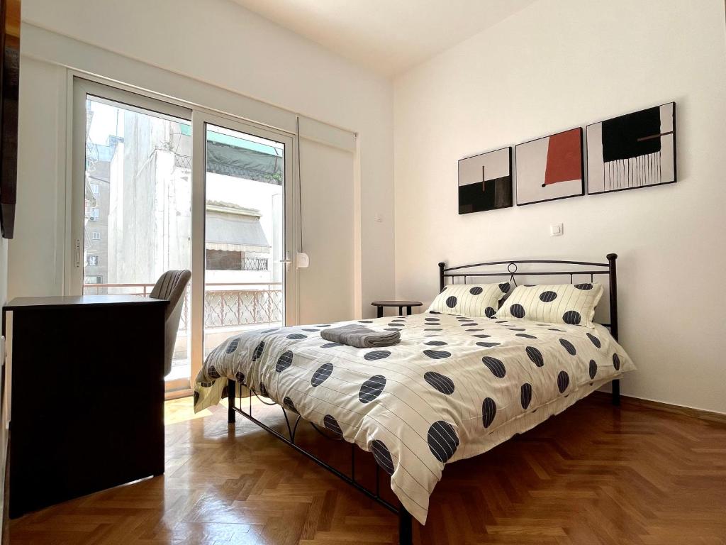 1 dormitorio con cama y ventana grande en 4-bedroom Family apartment in the center of Athens, en Atenas