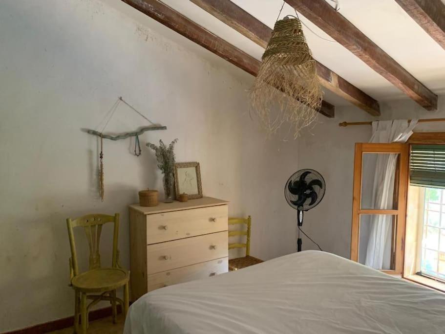 um quarto com uma cama, uma cómoda e uma ventoinha em Chalet con piscina privada em Blanca