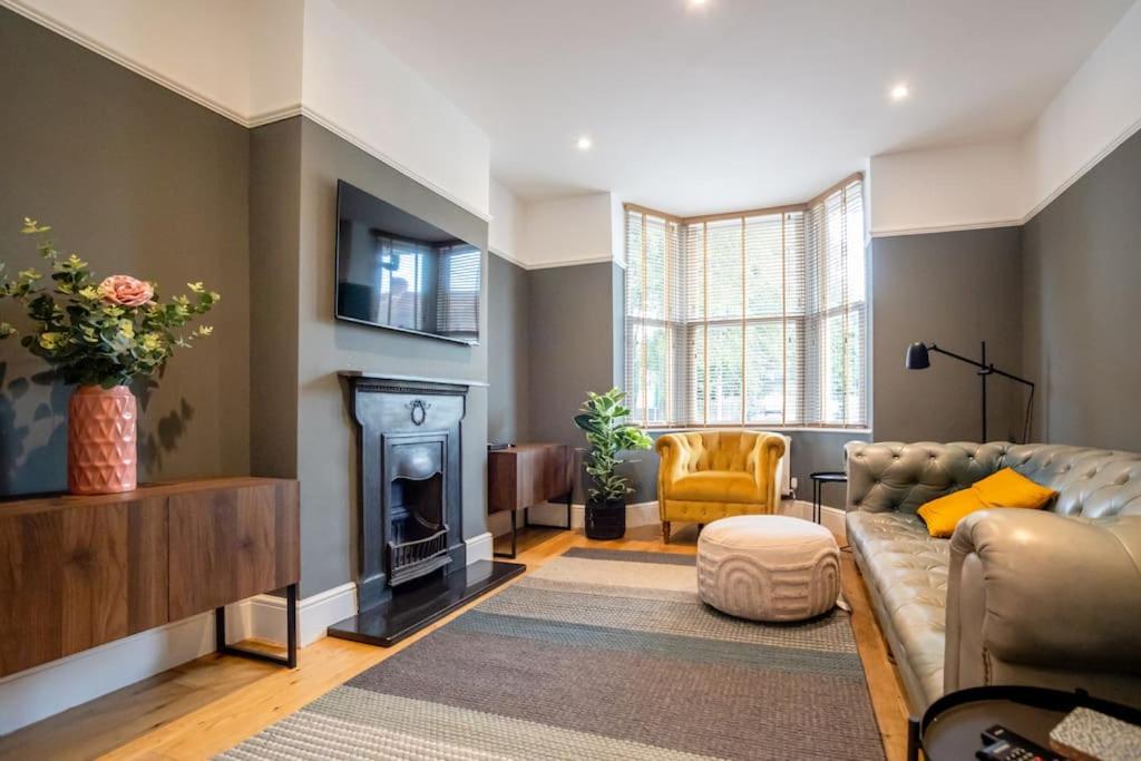 Clifton Villa By RentMyHouse في هيريفورد: غرفة معيشة مع أريكة ومدفأة