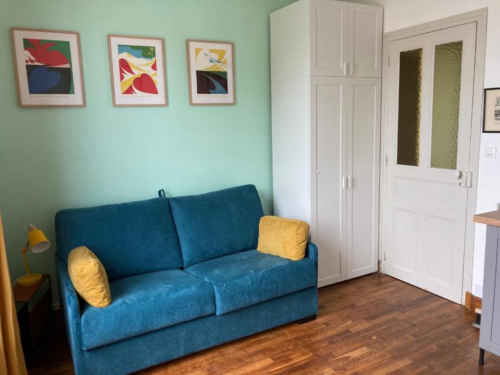 a blue couch sitting in a living room at Studio Cosy, Lumineux et Bien situé. in Lorient