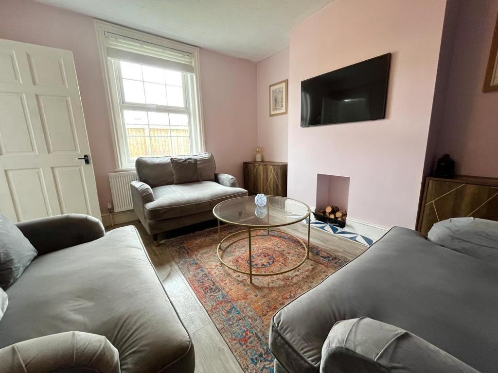 uma sala de estar com um sofá e uma mesa em Woodside Road, Southbourne em Bournemouth
