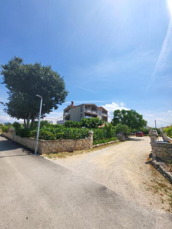 a dirt road with a house in the background at Apartmani Milka in Vrsi