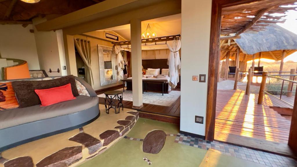 a master bedroom with a bed and a balcony at Kalahari Red Dunes Lodge in Kalkrand