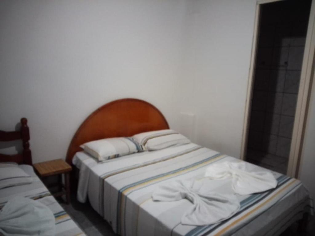Cette petite chambre comprend un lit avec des draps et des oreillers blancs. dans l'établissement HOTEL REAL, à Votuporanga