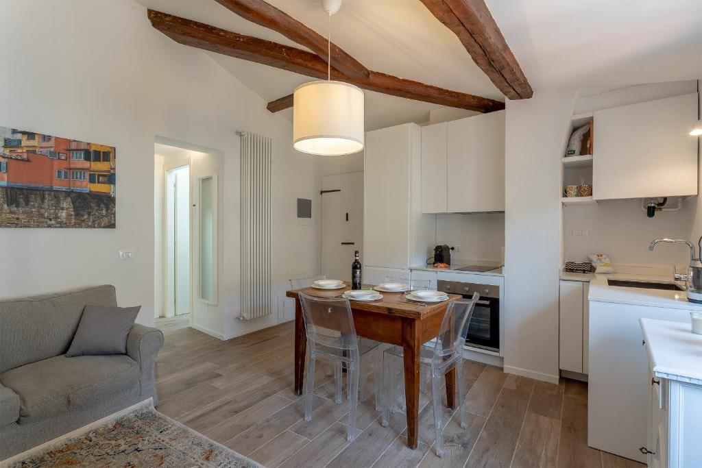 een keuken en een woonkamer met een tafel en een bank bij Piazza Dei Rossi Due View in Florence