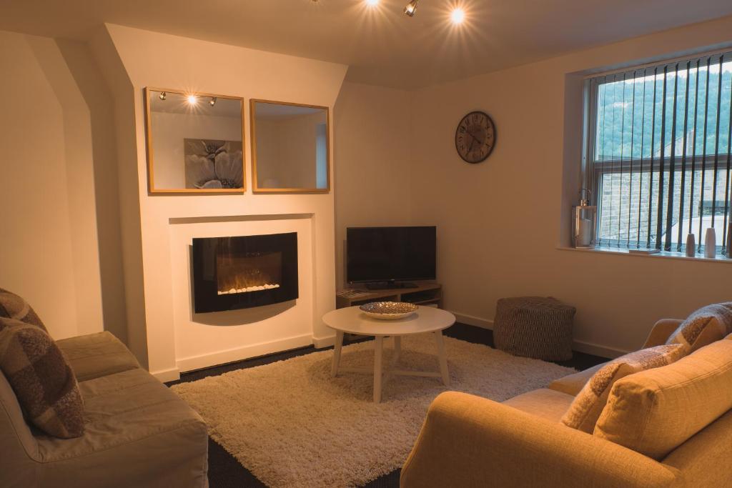 ein Wohnzimmer mit einem Sofa und einem Kamin in der Unterkunft Peaceful Retreat Suite - Simple2let Serviced Apartments in Halifax