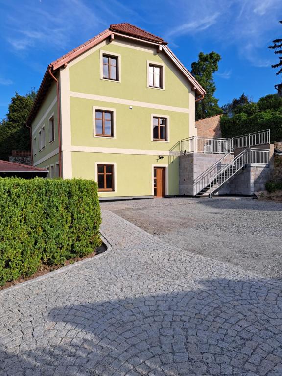 a large yellow house with a driveway at Vila František in Plasy