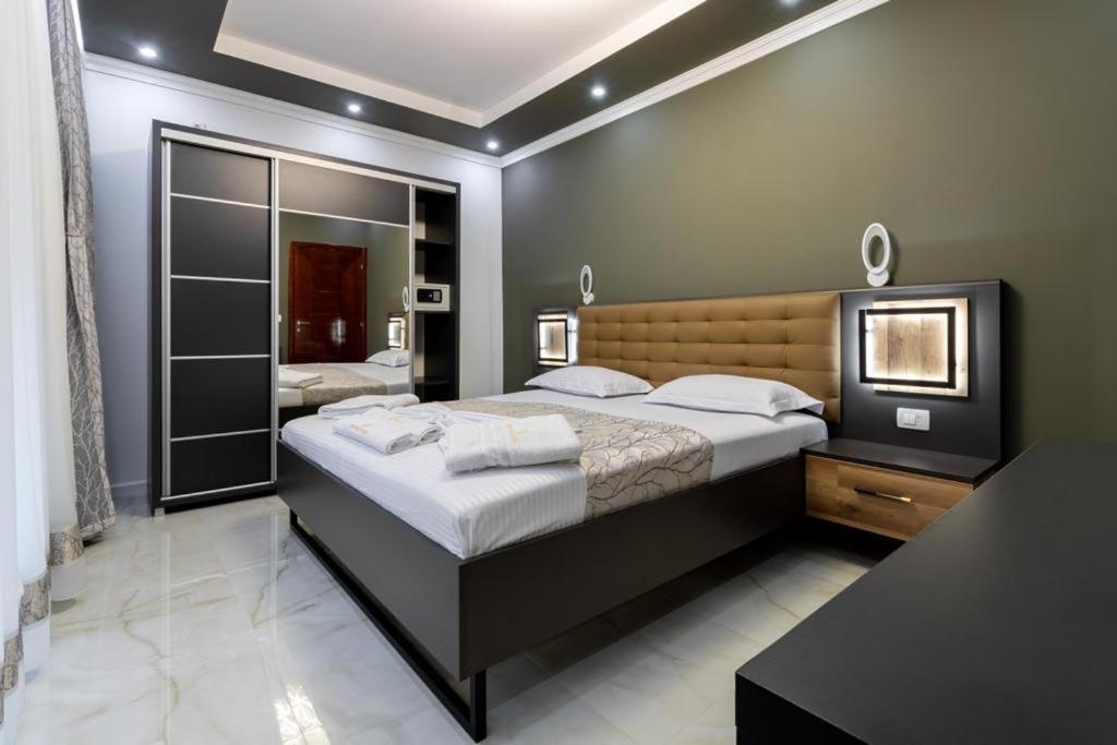 a bedroom with a large bed and a mirror at Apart-Hotel President in Ulcinj