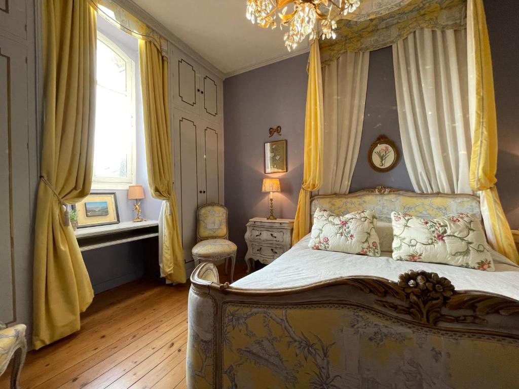 a bedroom with a canopy bed and a window at Maison d'Hercule in Mayenne