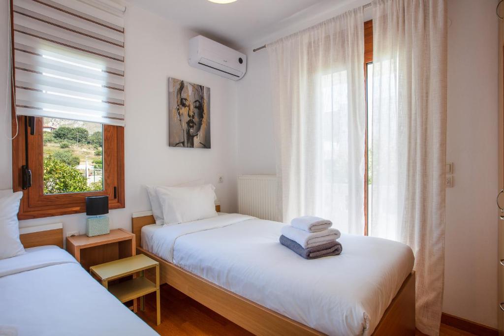 2 camas en una habitación con ventana en Villa Elesia, en Koxaré