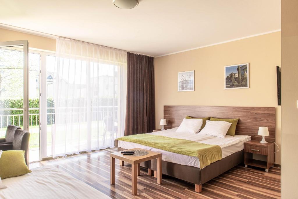 a hotel room with a bed and a large window at Ośrodek Wypoczynkowy Marcela in Mielno