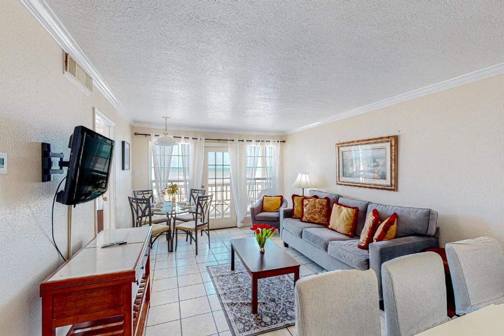 a living room with a couch and a table at Beachfront Haven in Galveston