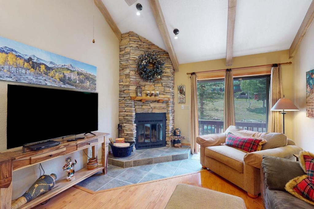 sala de estar con TV de pantalla plana y chimenea en Brown Bear Lodge #322, en Durango Mountain Resort