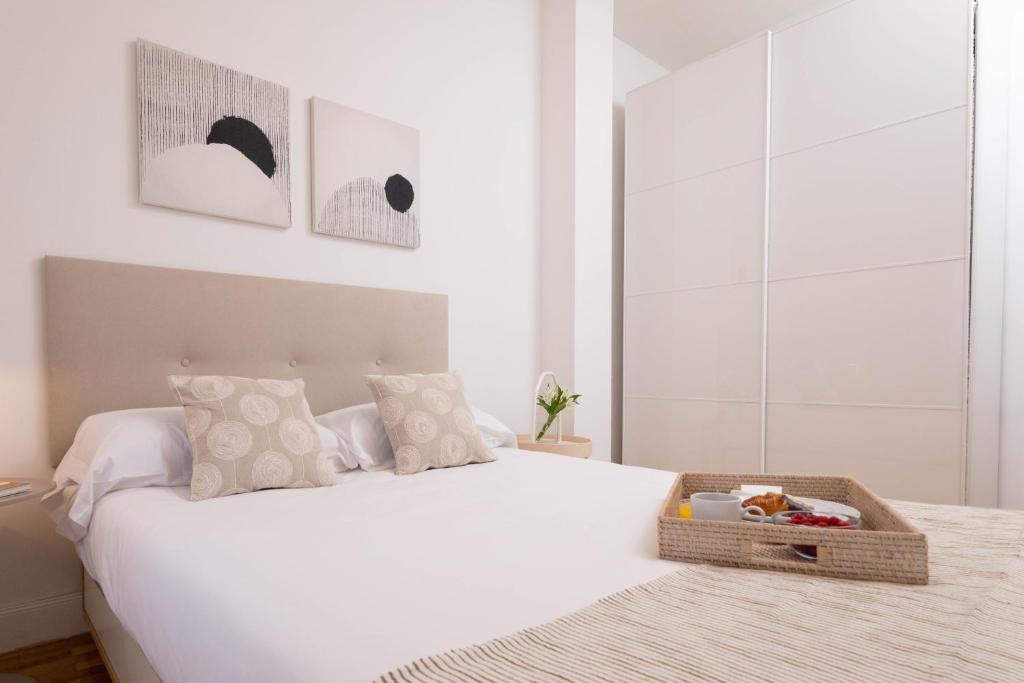 een slaapkamer met een wit bed en een dienblad bij Perfect one bedroom apartment in Madrid