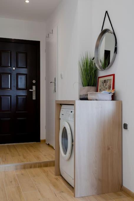 a laundry room with a washing machine and a mirror at Studio z widokiem na rzekę in Przemyśl