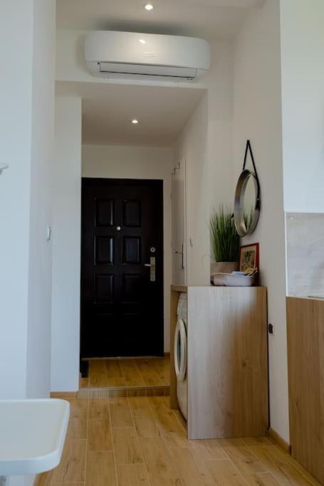 a bathroom with a black door and a washing machine at Studio z widokiem na rzekę in Przemyśl
