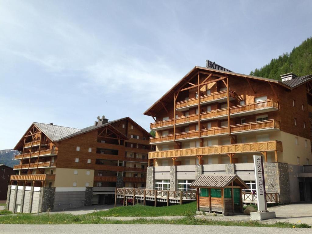 un grand bâtiment avec une enseigne devant dans l'établissement Terrasses de Labrau - piscine, à Allos