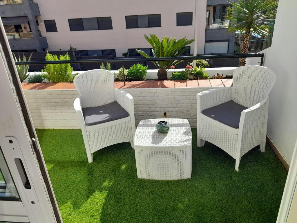 three chairs and a table on a balcony at Apartamento Marisma del Guadalquivir in Sanlúcar de Barrameda