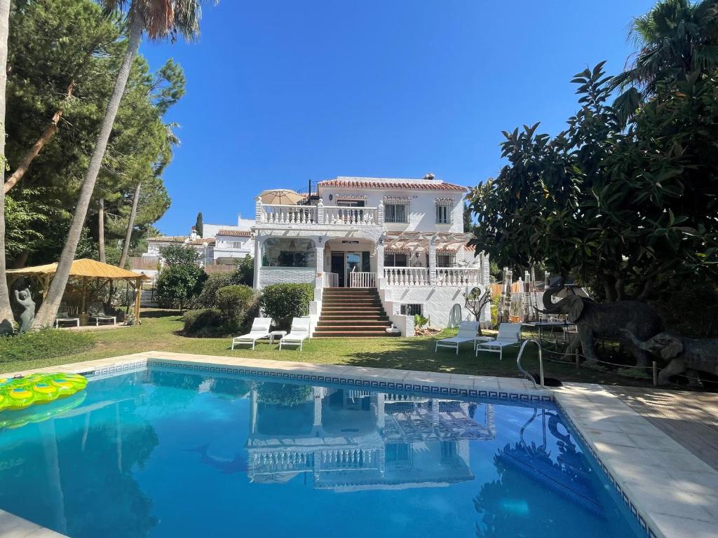 Casa Flora - Mijas Costa - Andalusië في ميخاس: بيت ابيض كبير مع مسبح