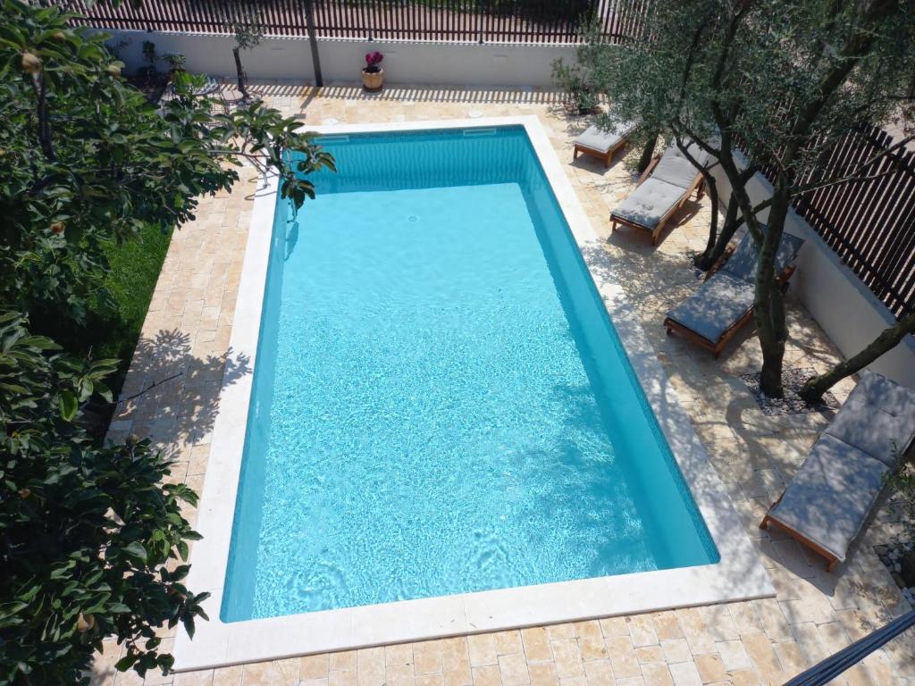 - une vue sur la piscine et ses 2 chaises dans l'établissement Apartment Kućica, à Zadar
