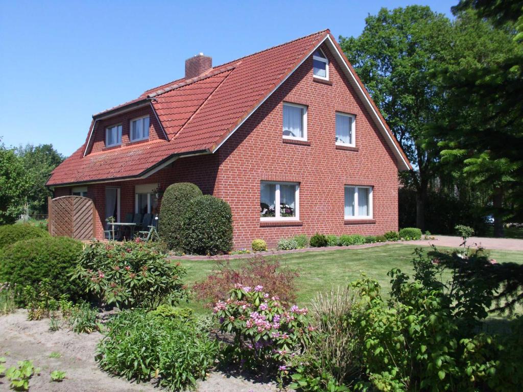 a red brick house with a red roof at Ferienwohnung Bohlen 65265 in Moormerland
