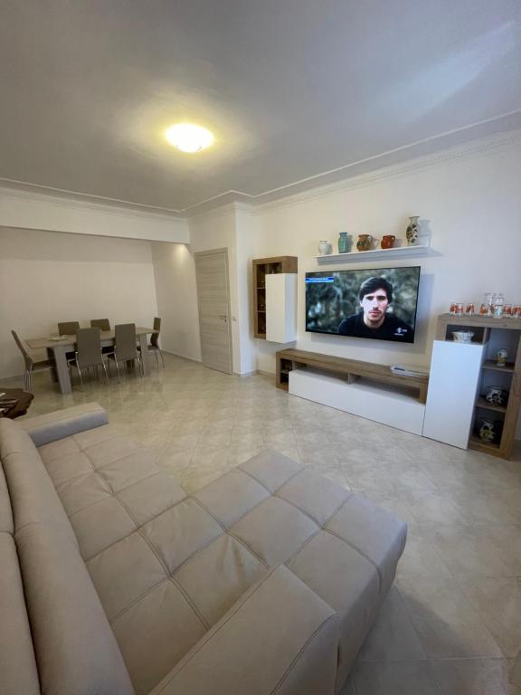 a living room with a couch and a flat screen tv at Happy house in Civitavecchia