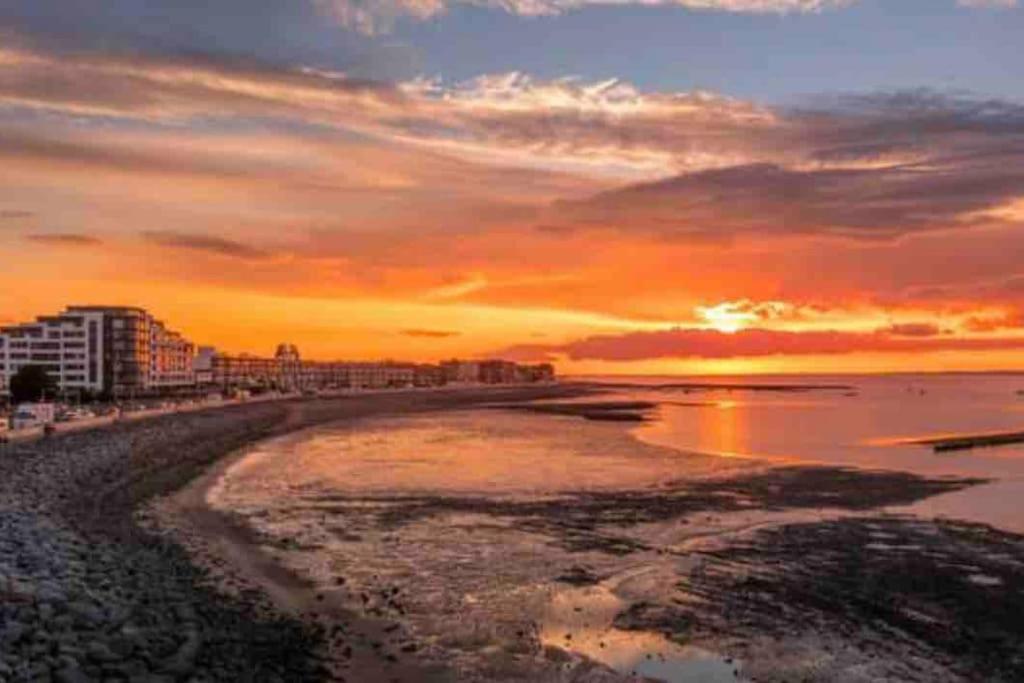 a beach with a sunset in the background at Apartment By The Sea! in Morecambe