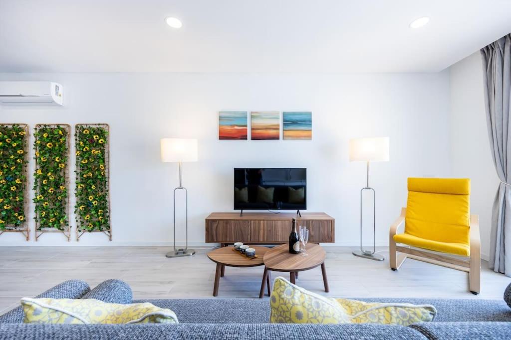 sala de estar con sofá azul y silla amarilla en The Hub central apartment Burgau, en Burgau