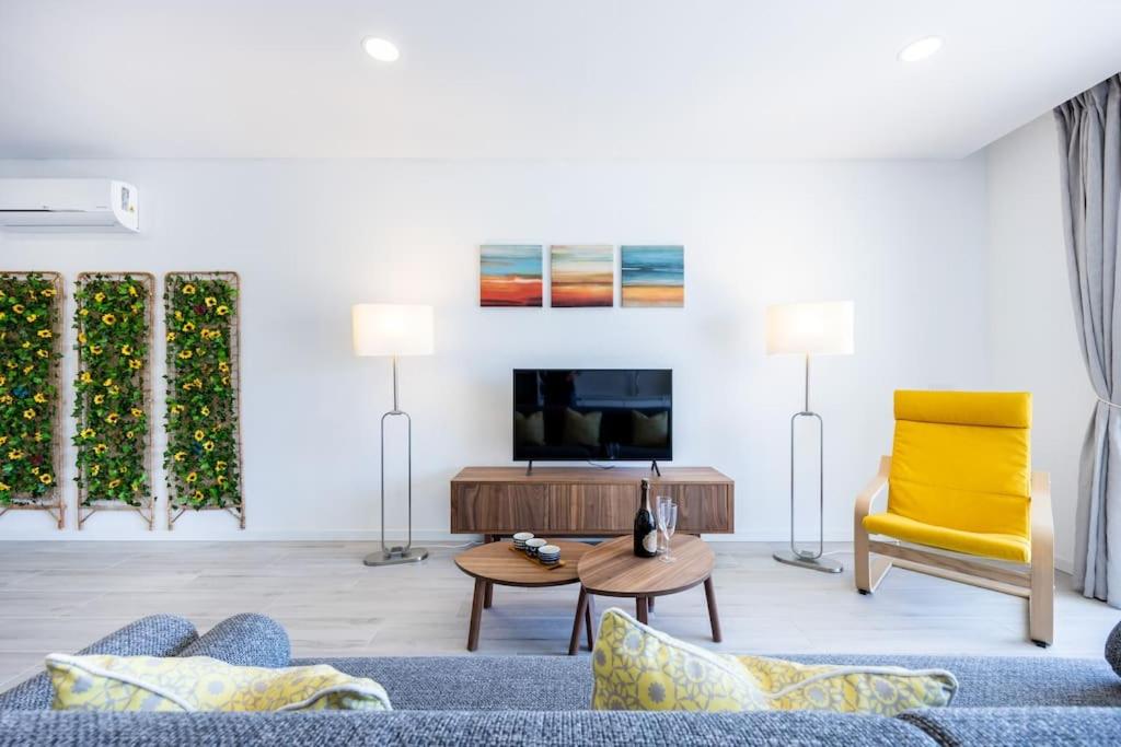 a living room with a blue couch and a yellow chair at The Hub central apartment Burgau in Burgau