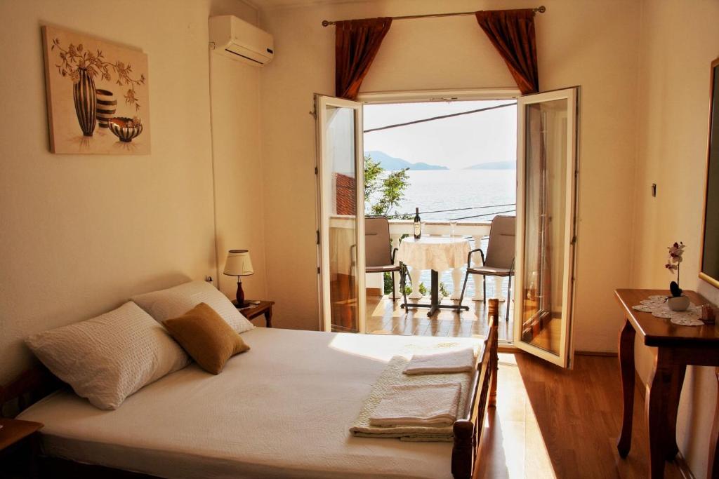 a bedroom with a bed and a view of the ocean at Apartman Mara in Sveti Juraj