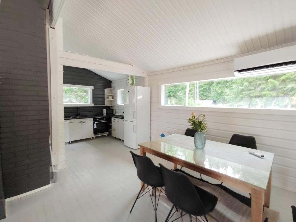 a kitchen and dining room with a table and chairs at Lake Cottage with sauna (near City) in Jyväskylä