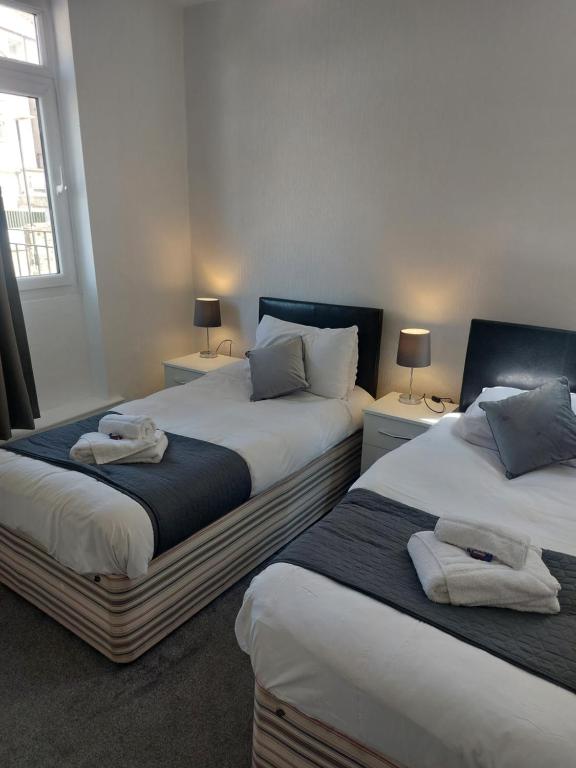 dos camas sentadas una al lado de la otra en un dormitorio en The Sanderling, en Morecambe