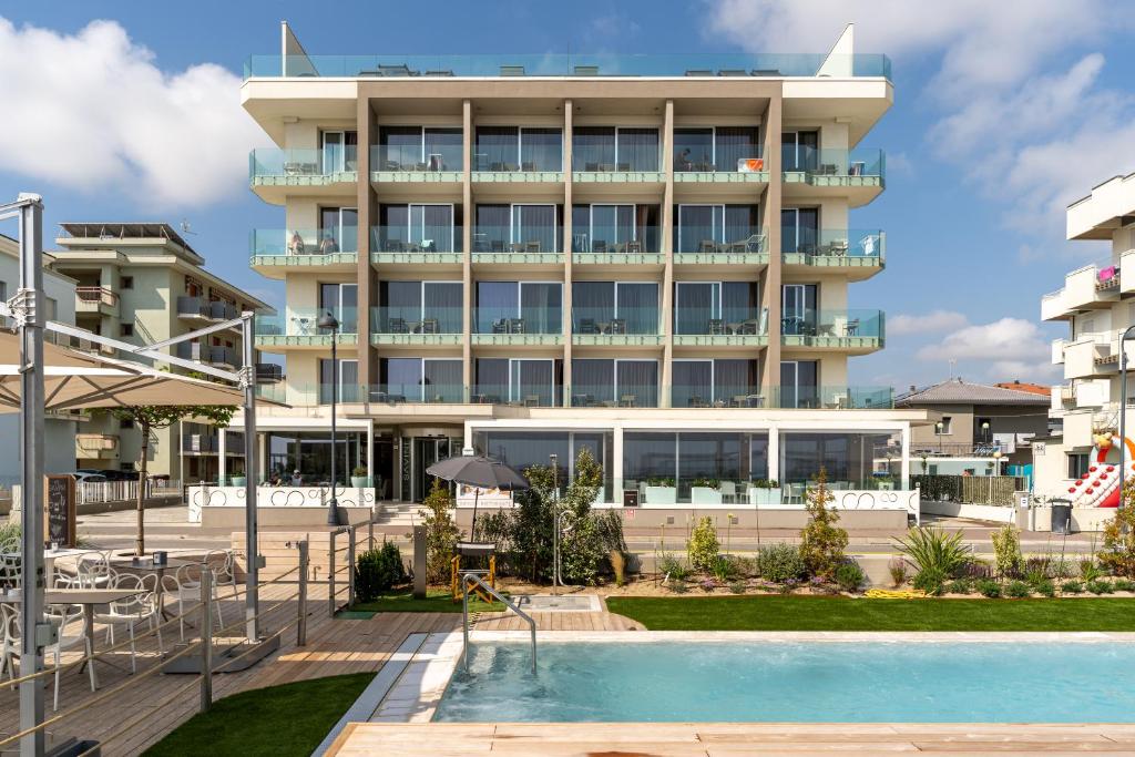 un hotel con piscina frente a un edificio en Hotel Savini, en Bellaria-Igea Marina