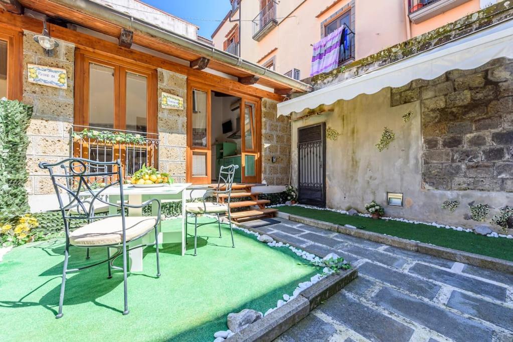 um pátio com uma mesa e cadeiras num relvado em [Sorrento Coast] Villa with garden Il Glicine em Piano di Sorrento