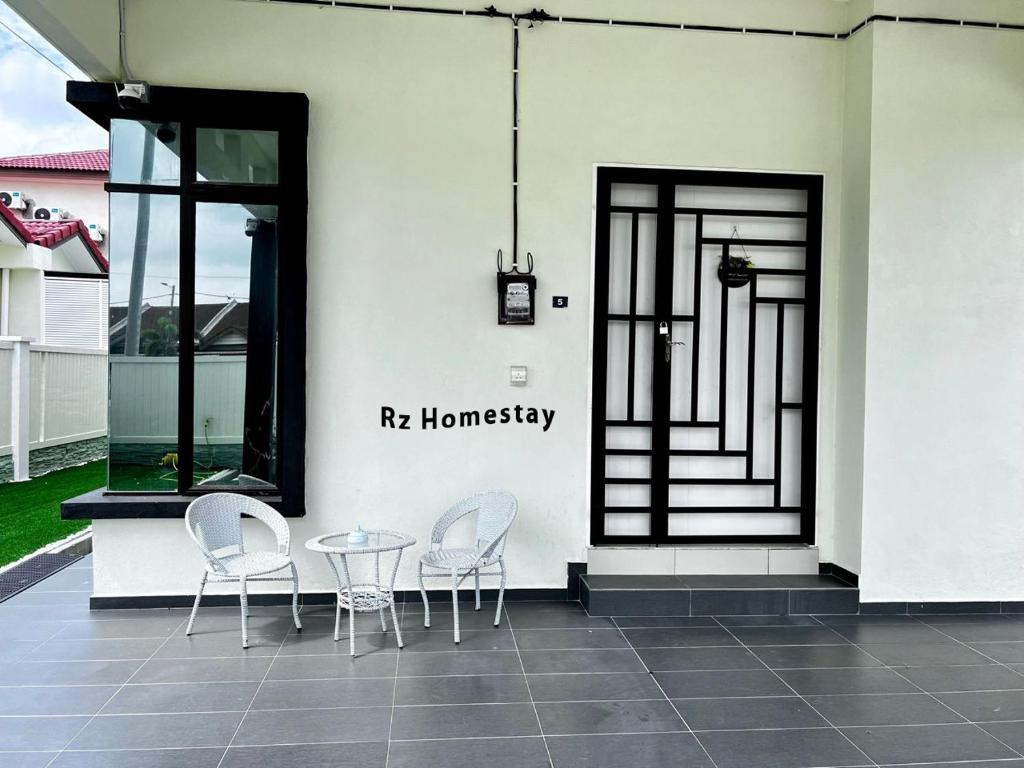 a pair of chairs and a table on a patio at Rz Homestay in Malacca