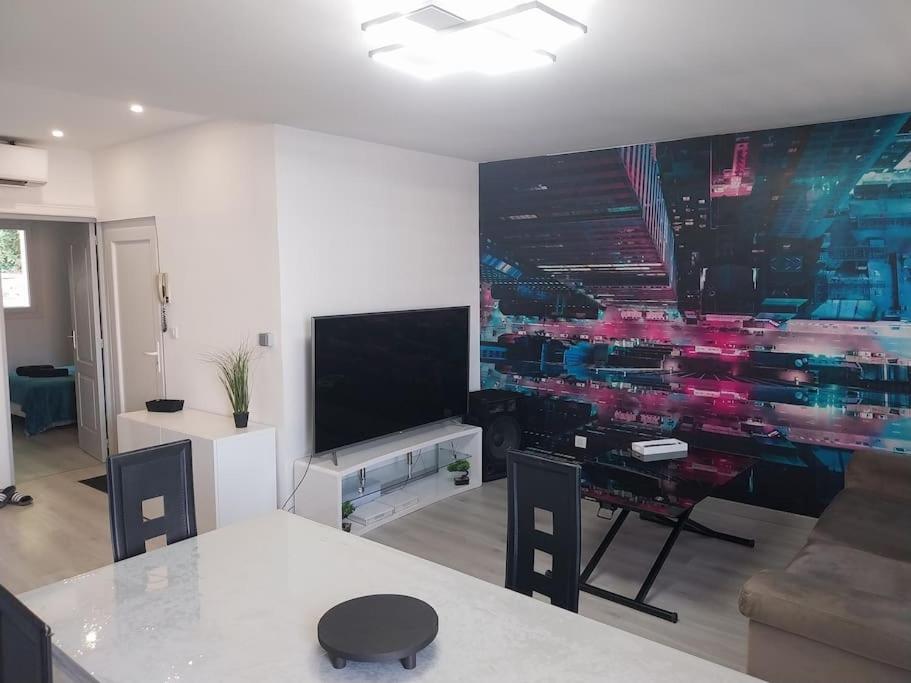 a living room with a large painting on the wall at Appartement sandonato in Clermont-lʼHérault