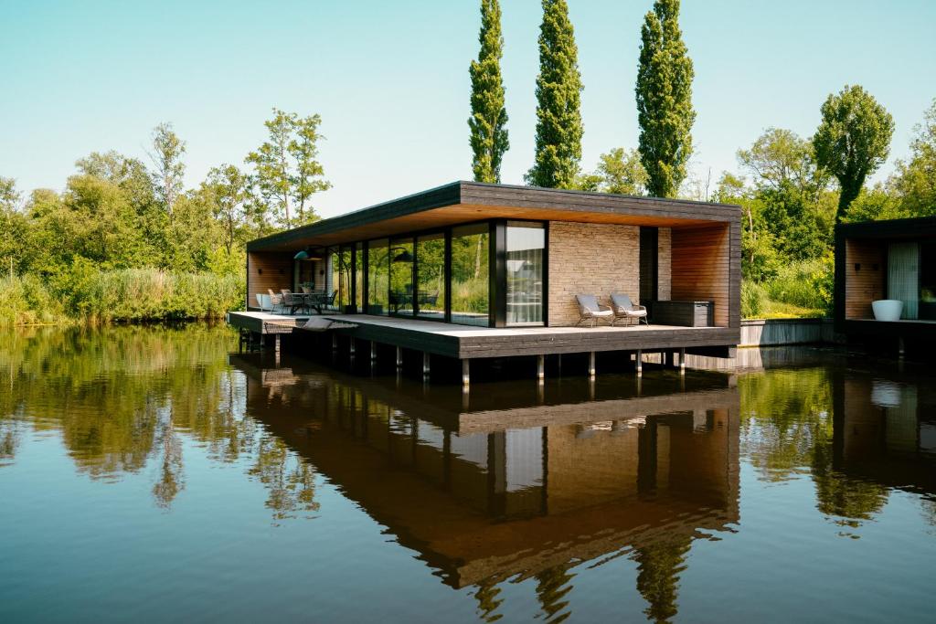 een huis op het water met zijn reflectie bij Haven Lake Village in Kortenhoef