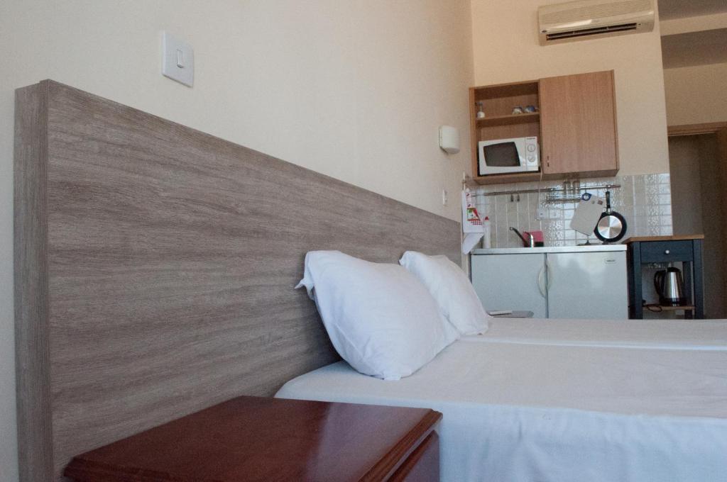 um quarto com uma cama branca e uma parede em Tuck Inn em Larnaka