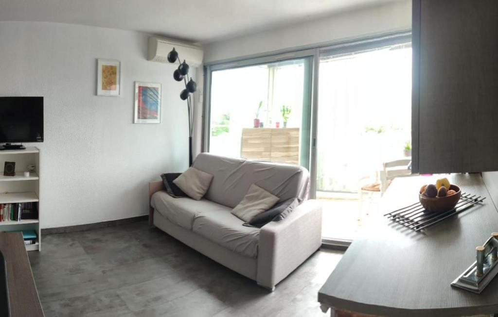 sala de estar con sofá blanco y mesa en Appartement T2 à 300m de la mer, en Palavas-les-Flots